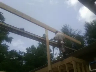 Carpenter setting a ridge beam over a new addition frame — Ice Dam Removal by Roofing Brothers in Manheim
