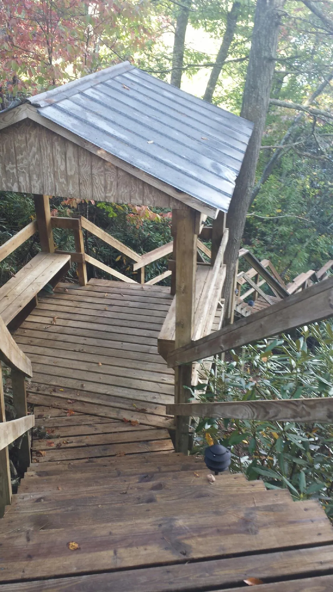 Metal roofed shelter over wooden steps on a wooded walkway — Skylight Repair & Installation work by our crew in Manheim